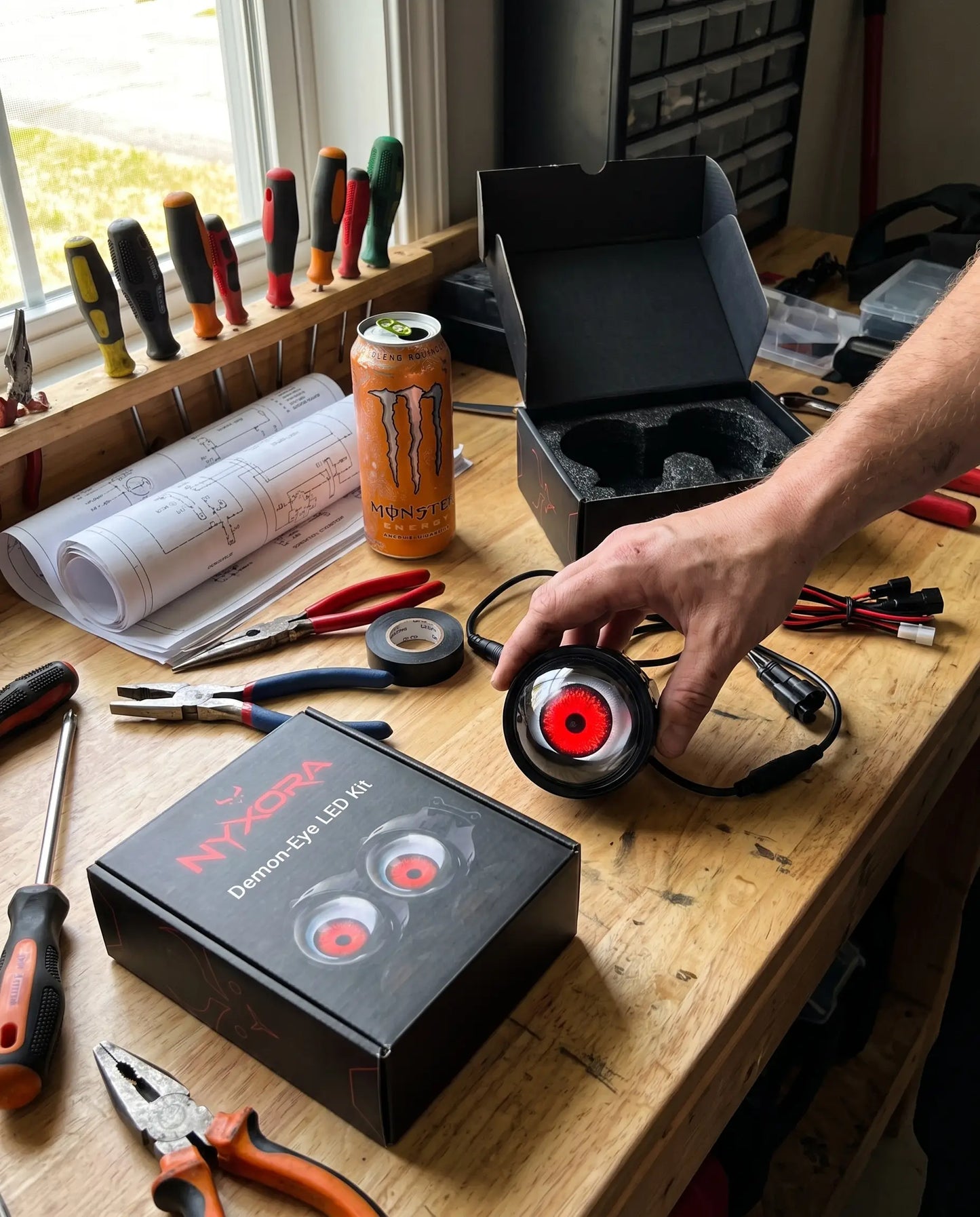Nyxora Demon-Eye LED Kit box open on garage workbench with tools and wiring during install