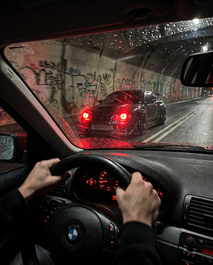 POV driving shot through a night tunnel with another car's Nyxora Demon-Eye LED headlights glowing red